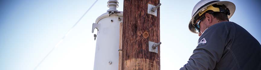 Worker on telephone pull wearing FR uniforms