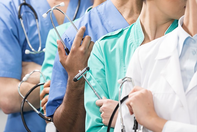 Image of men and women wearing healthcare uniforms